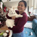 Ana pictured with a white cat in her arms